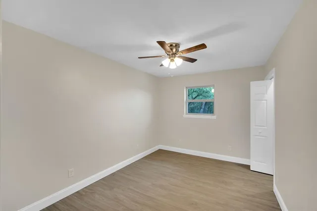 an empty room with a window and a fan