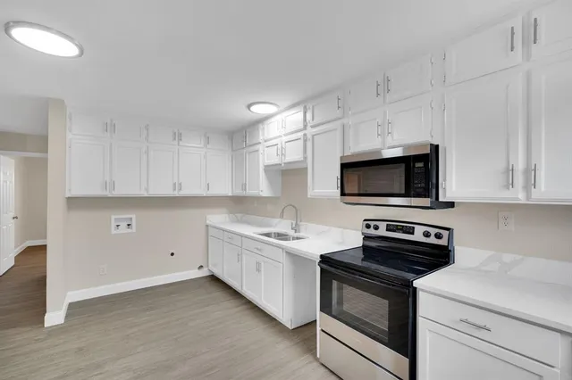 a kitchen with white cabinets and stainless steel appliances