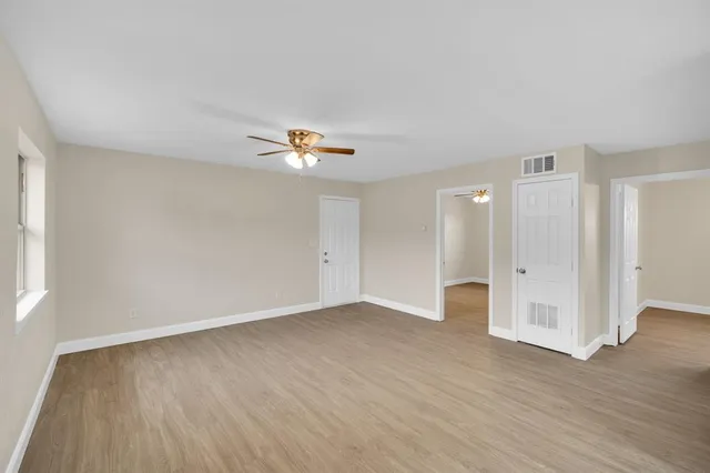 an empty room with wooden floor and window