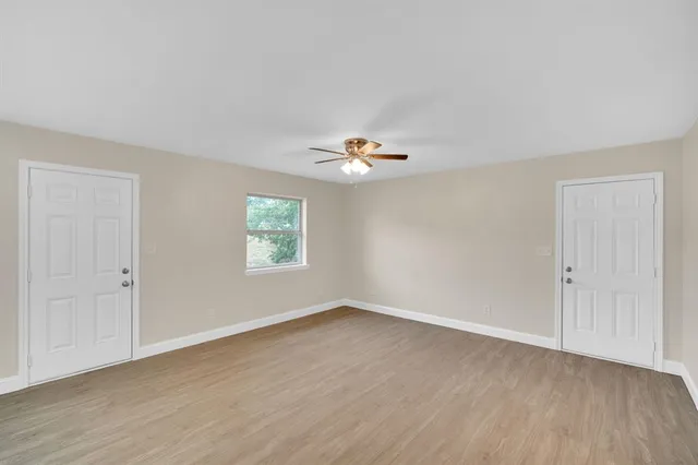 a view of a livingroom with a window and wooden floor