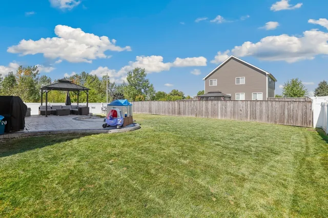 a backyard of a house with table and chairs