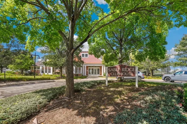 a front view of a house with garden and trees