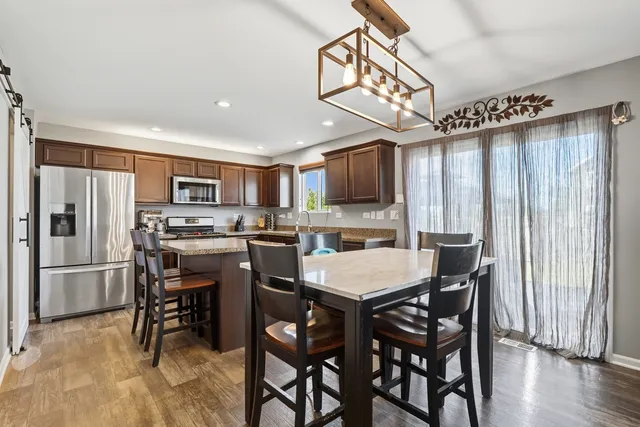 a kitchen with a table chairs refrigerator and microwave