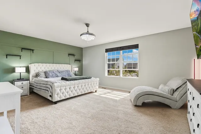 a spacious bedroom with a bed couch and window