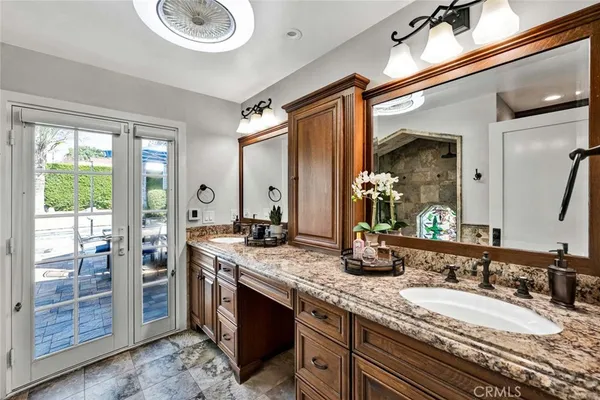 a bathroom with a granite countertop double vanity and a mirror
