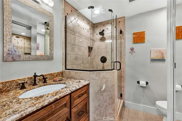 a bathroom with a granite countertop shower sink and mirror