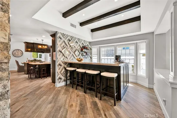 a dining hall with wooden floor and stainless steel appliances