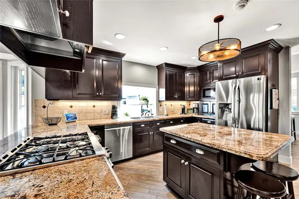 a kitchen with stainless steel appliances granite countertop a stove refrigerator a sink and dishwasher