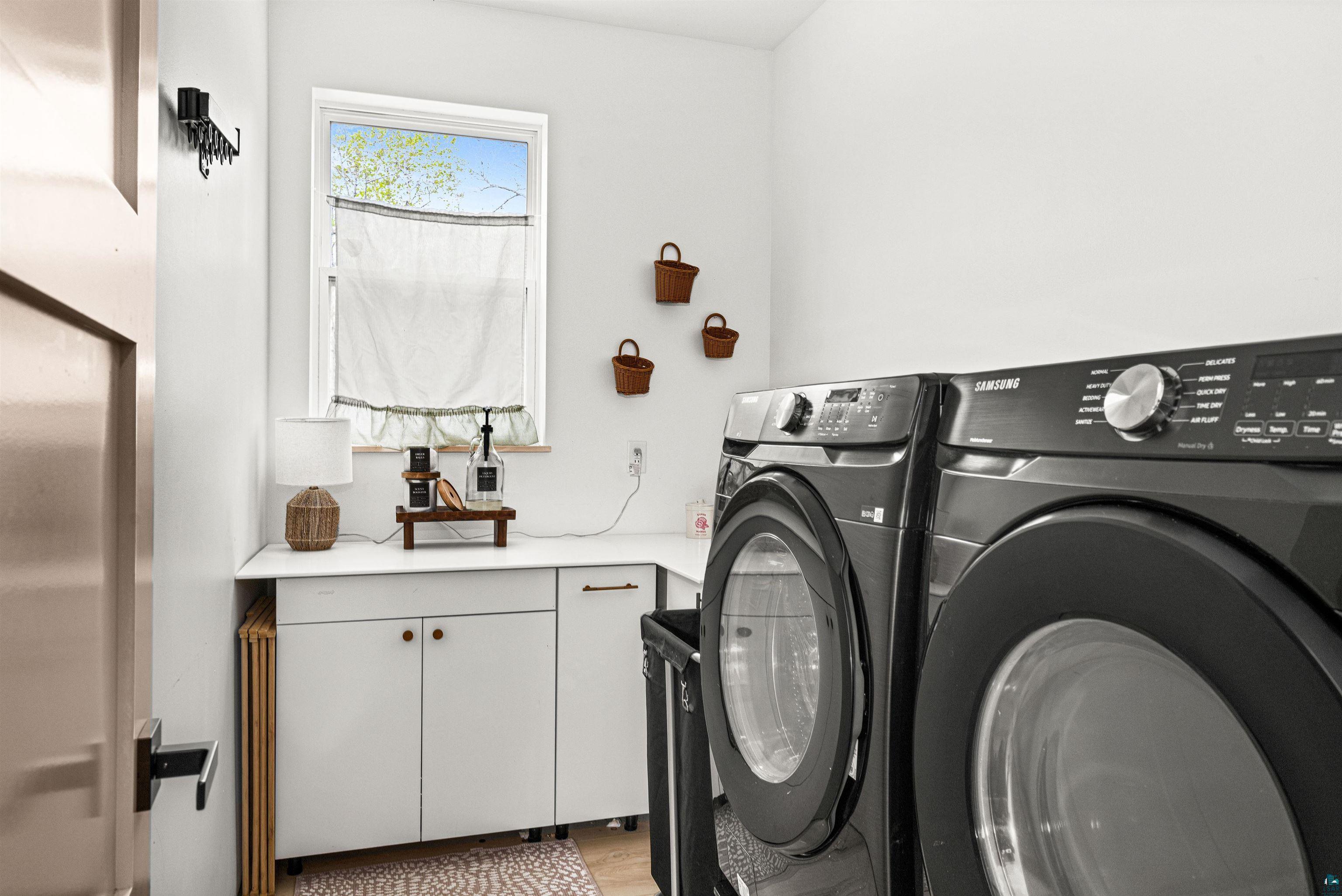 1825 East Shilhon Road Duluth, MN 55804 - Photo 19 of 37 Versatile laundry area featuring white cabinetry & front loading washer & dryer.