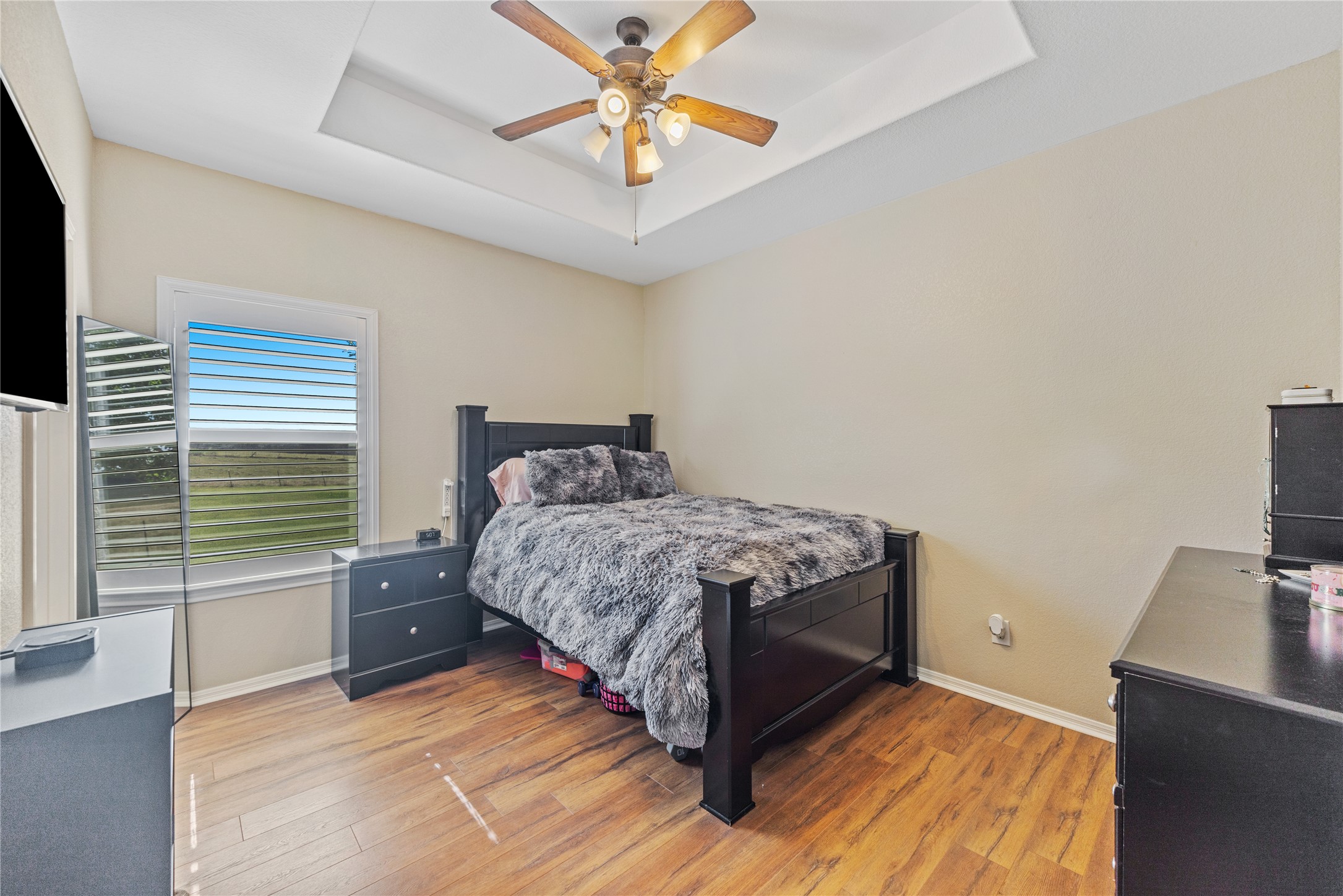 20145 Janak Road Coupland, TX 78615 - Photo 22 of 40 Well-lit sleeping quarters with a bright window, wood flooring, and a decorative ceiling fan in this secondary bedroom!