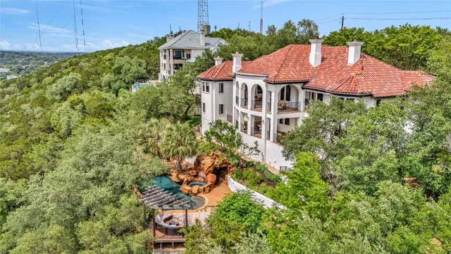 an aerial view of residential houses with outdoor space and trees