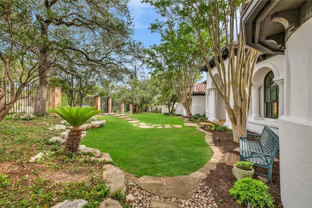 a view of a house with a big yard and large tree
