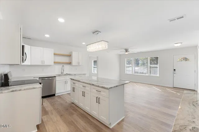 a kitchen with granite countertop white cabinets and white appliances