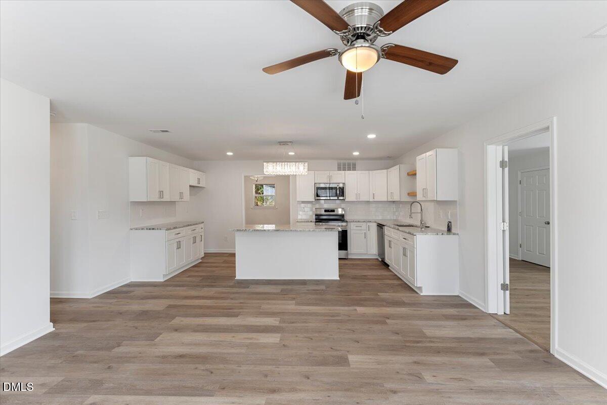 3305 Friar Tuck Road Raleigh, NC 27610 - Photo 4 of 18 a view of kitchen with kitchen island white cabinets and stainless steel appliances