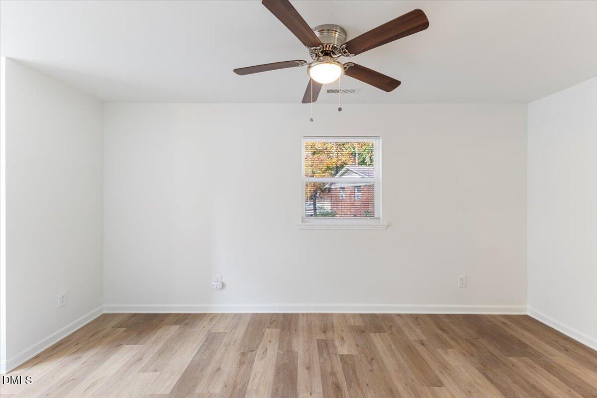 3305 Friar Tuck Road Raleigh, NC 27610 - Photo 7 of 18 an empty room with a window and ceiling fan