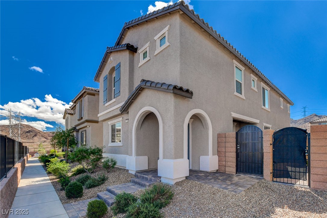 1360 Cerulean Avenue Henderson, NV 89002 - Photo 1 of 62 View of side of home with a gate, a tiled roof, and stucco siding