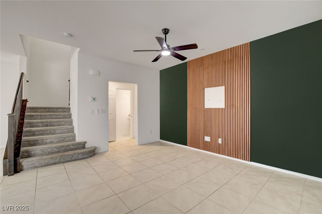 1360 Cerulean Avenue Henderson, NV 89002 - Photo 11 of 62 Unfurnished room featuring stairway, light tile patterned floors, a ceiling fan, and wood walls
