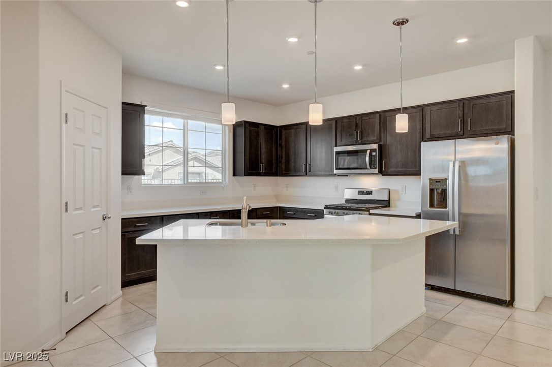1360 Cerulean Avenue Henderson, NV 89002 - Photo 14 of 62 Kitchen featuring stainless steel appliances, pendant lighting, a center island with sink, dark brown cabinetry, and recessed lighting
