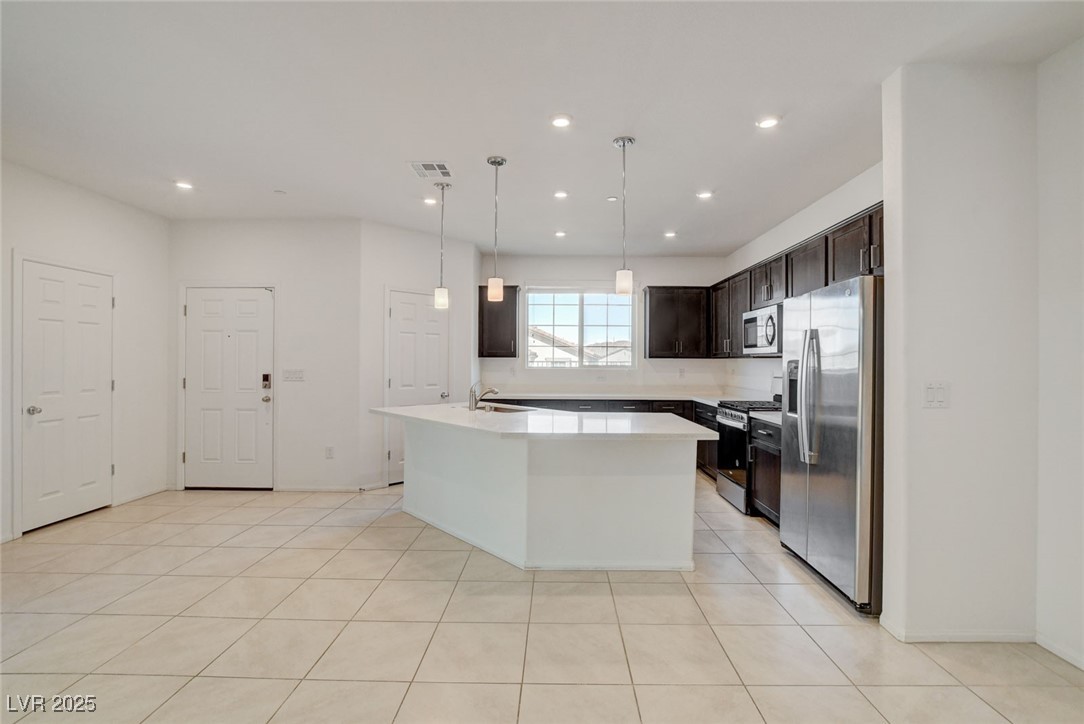 1360 Cerulean Avenue Henderson, NV 89002 - Photo 15 of 62 Kitchen with appliances with stainless steel finishes, dark brown cabinetry, a center island with sink, hanging light fixtures, and recessed lighting