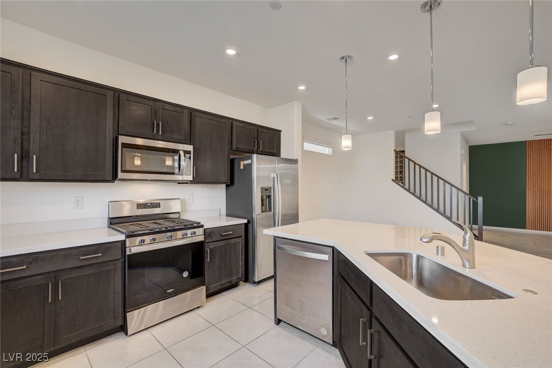 1360 Cerulean Avenue Henderson, NV 89002 - Photo 19 of 62 Kitchen featuring stainless steel appliances, dark brown cabinetry, pendant lighting, light tile patterned flooring, and recessed lighting