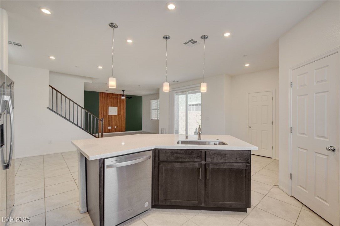 1360 Cerulean Avenue Henderson, NV 89002 - Photo 20 of 62 Kitchen with dark brown cabinets, stainless steel appliances, light tile patterned floors, an island with sink, and recessed lighting