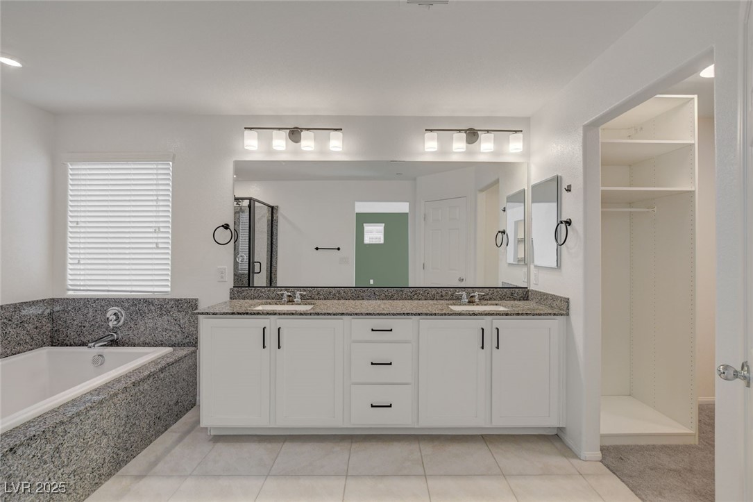 1360 Cerulean Avenue Henderson, NV 89002 - Photo 36 of 62 Bathroom featuring double vanity, light tile patterned floors, a stall shower, a garden tub, and a closet