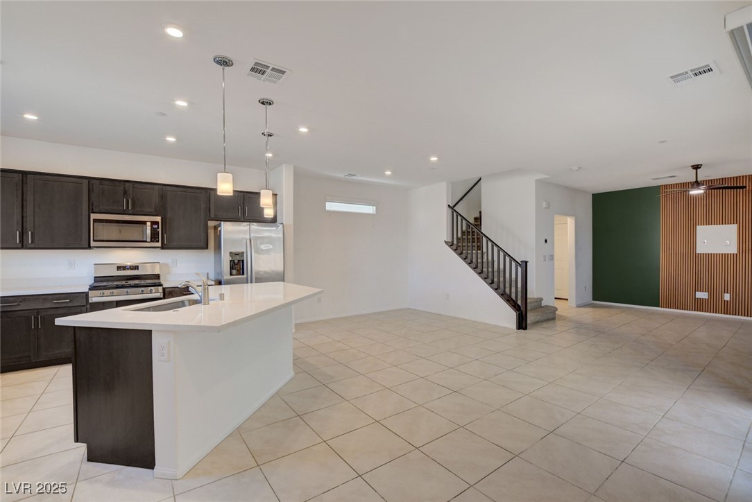 1360 Cerulean Avenue Henderson, NV 89002 - Photo 5 of 62 Kitchen with hanging light fixtures, dark brown cabinetry, appliances with stainless steel finishes, a kitchen island with sink, and ceiling fan