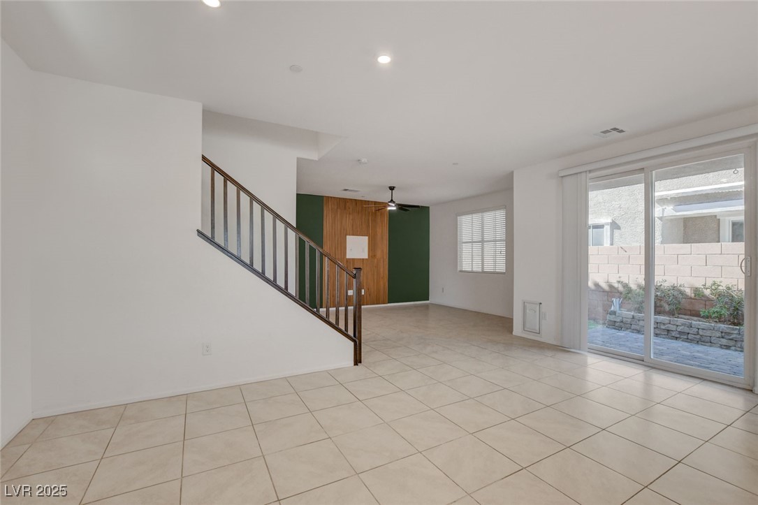 1360 Cerulean Avenue Henderson, NV 89002 - Photo 7 of 62 Empty room with stairs, ceiling fan, light tile patterned flooring, recessed lighting, and wooden walls