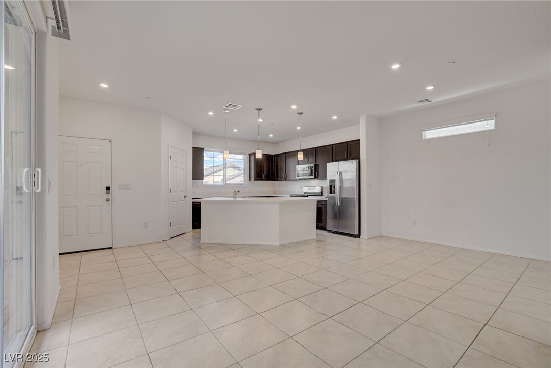 1360 Cerulean Avenue Henderson, NV 89002 - Photo 62 of 62 Kitchen featuring pendant lighting, light countertops, stainless steel appliances, dark brown cabinetry, and open floor plan