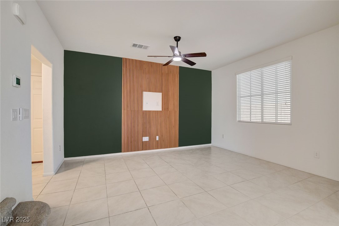 1360 Cerulean Avenue Henderson, NV 89002 - Photo 9 of 62 Spare room with wood walls, light tile patterned floors, ceiling fan, and an accent wall