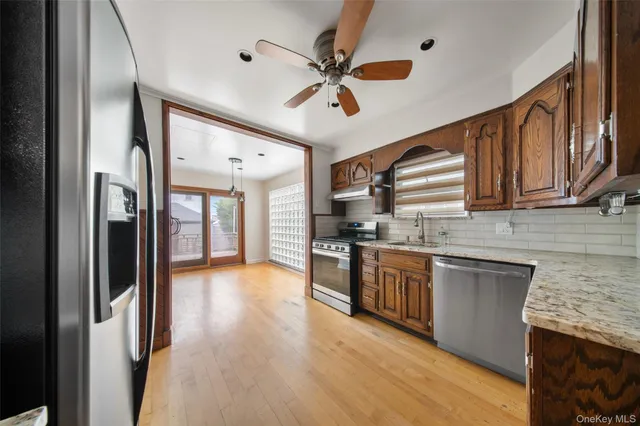 a kitchen with stainless steel appliances granite countertop hardwood floor sink stove dining table and chairs