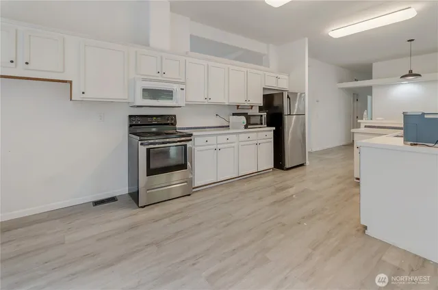 a kitchen with granite countertop white cabinets and stainless steel appliances