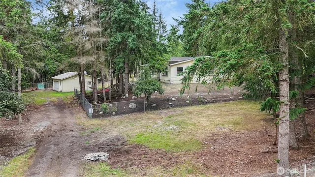 a view of a house with backyard and a tree