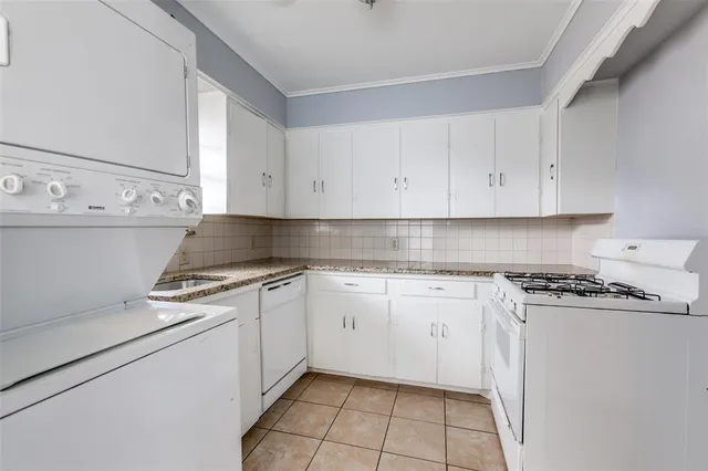 a kitchen with granite countertop cabinets and white appliances