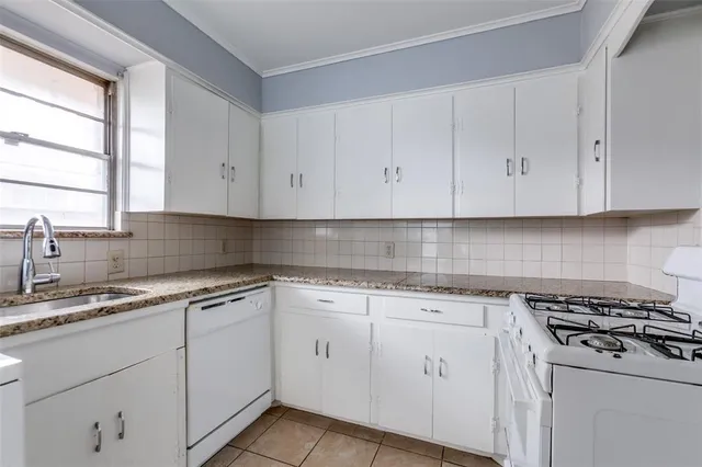 a kitchen with cabinets appliances a sink and a window