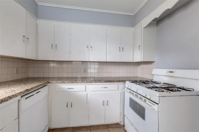 a kitchen with granite countertop cabinets and white appliances