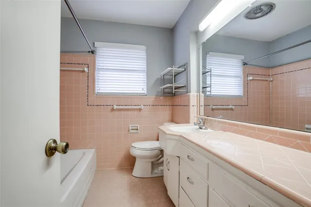 a bathroom with a granite countertop toilet a sink and a bathtub