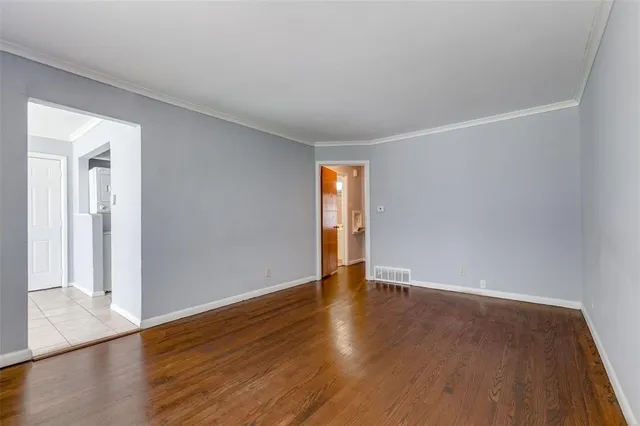 a view of an empty room with wooden floor