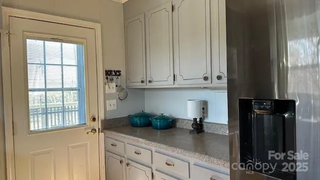 a kitchen with stainless steel appliances granite countertop white cabinets and a window