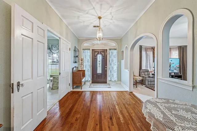 a view of a hallway with wooden floor and a chandelier