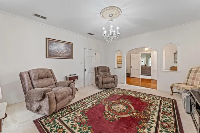 a living room with furniture chandelier and a rug