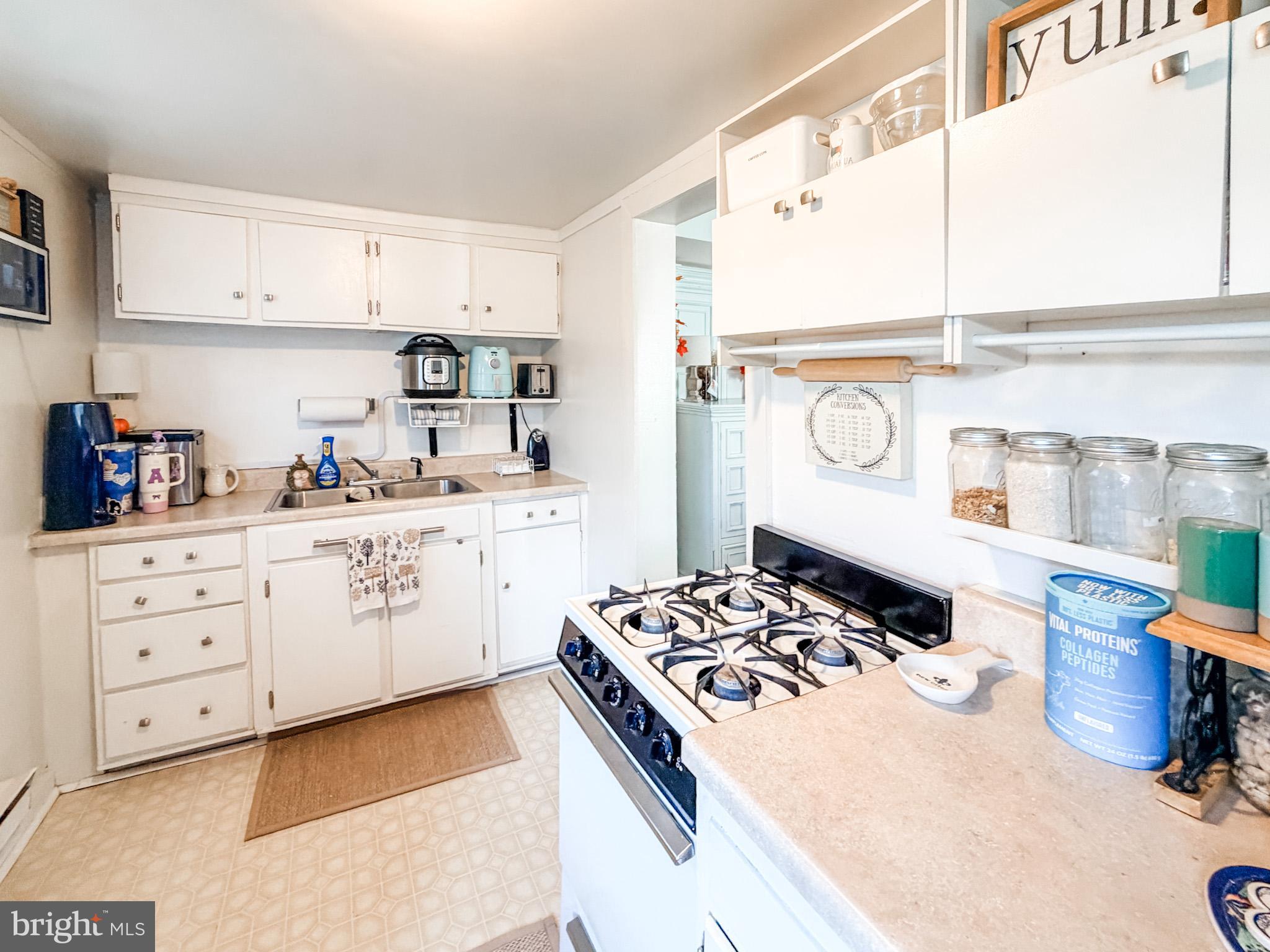 7267 Benedict Avenue Benedict, MD 20612 - Photo 13 of 28 a kitchen with a stove a sink and a refrigerator