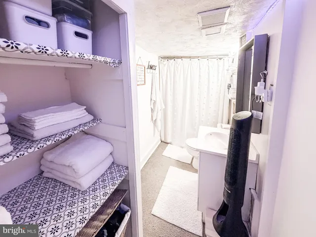 a bedroom with a bed and a large mirror next to a window