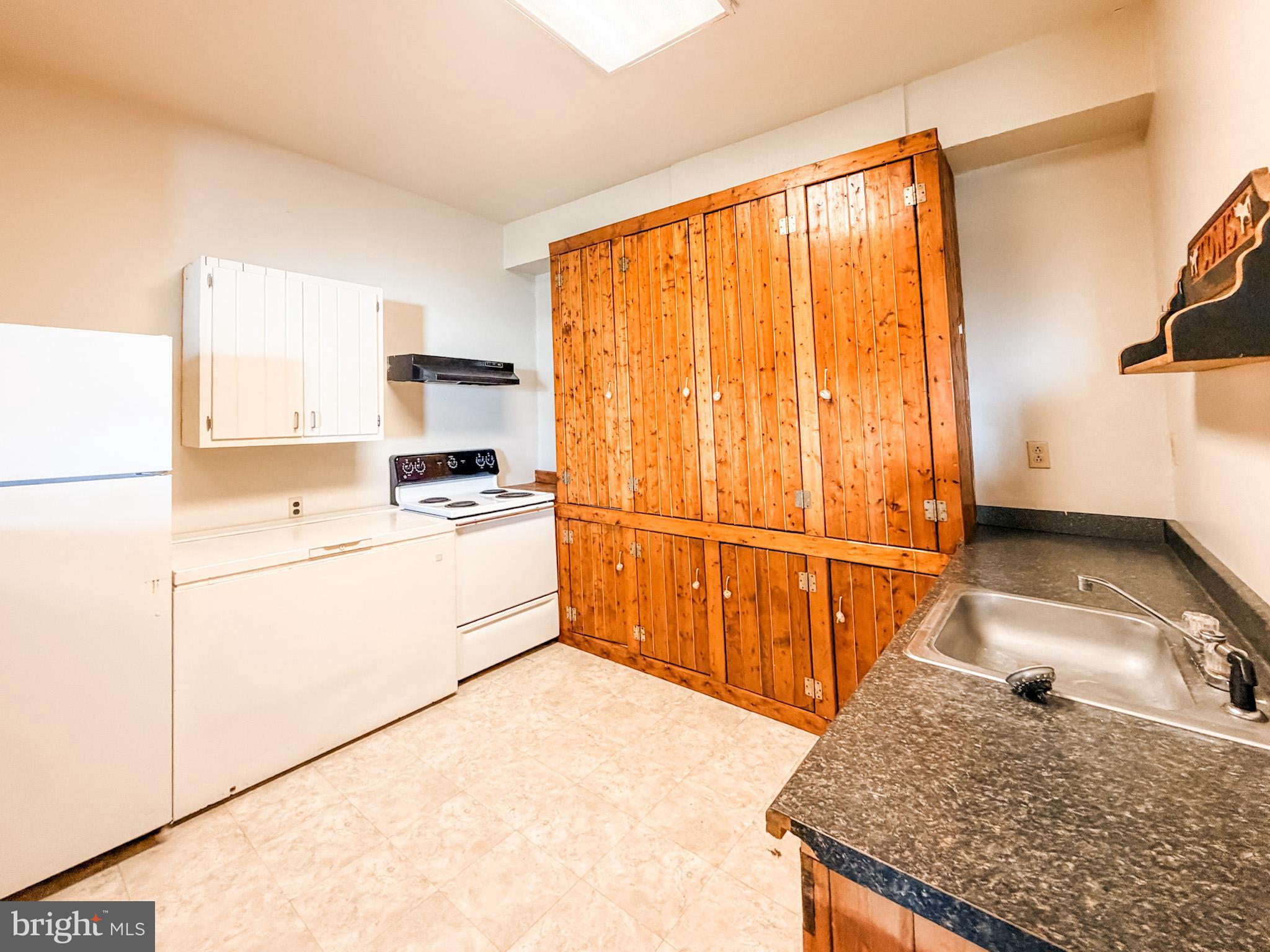 7267 Benedict Avenue Benedict, MD 20612 - Photo 24 of 28 a kitchen with a stove a refrigerator and countertop