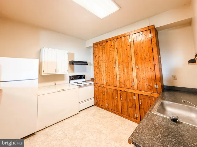 a kitchen with stainless steel appliances a refrigerator a stove a sink a chimney and dining table chair