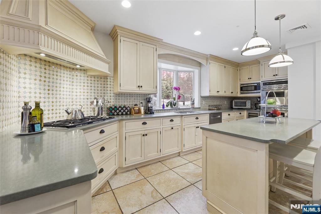 14 Old Smith Road Tenafly, NJ 07670 - Photo 19 of 50 a kitchen with stainless steel appliances kitchen island granite countertop a sink a stove a refrigerator and cabinets