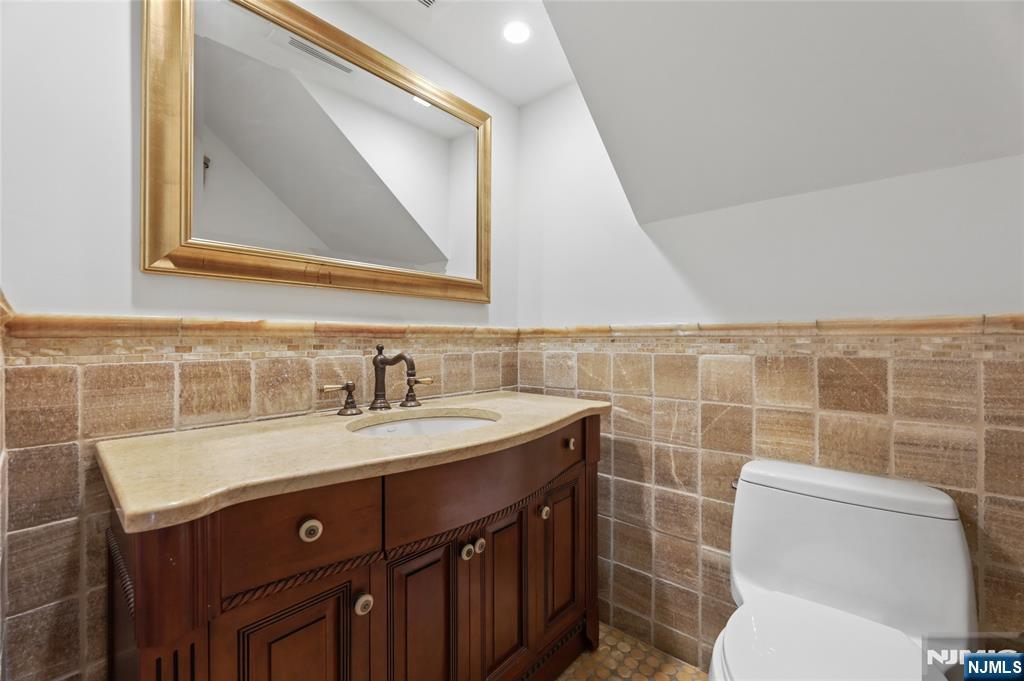 14 Old Smith Road Tenafly, NJ 07670 - Photo 25 of 50 a bathroom with a toilet sink vanity and mirror