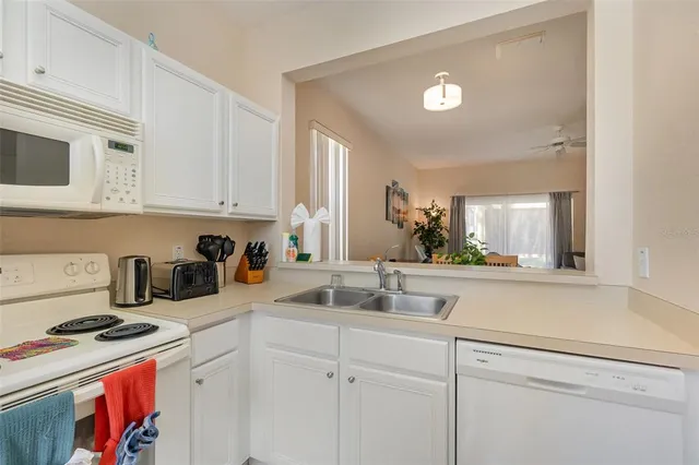a kitchen with stainless steel appliances granite countertop a sink a stove and cabinets