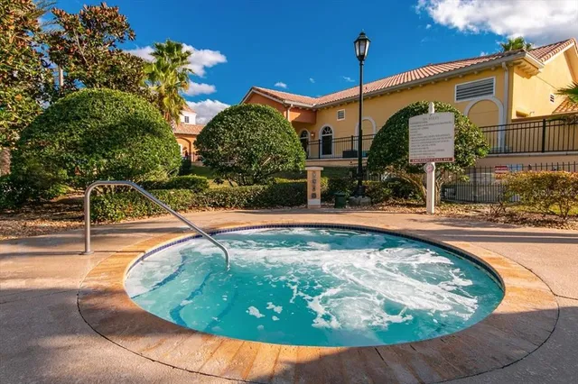 a view of a backyard with swimming pool and sitting area