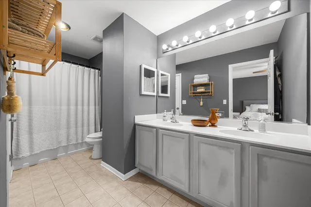 a bathroom with a double vanity sink mirror and toilet